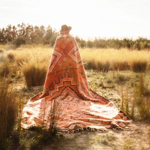 a boho marroccan rug on a golden grass field at central coast. captured by ingrid photograher